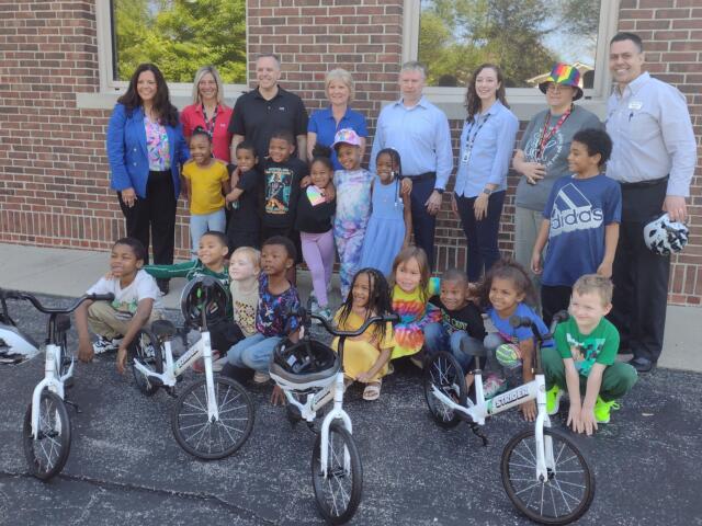 Mayor Misty Buscher (far left) along with principal Jim Hayes (far right) pose with some kindergarteners and their new training bikes.
