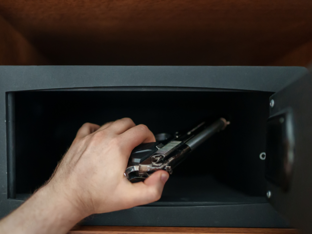 Man putting gun in safe